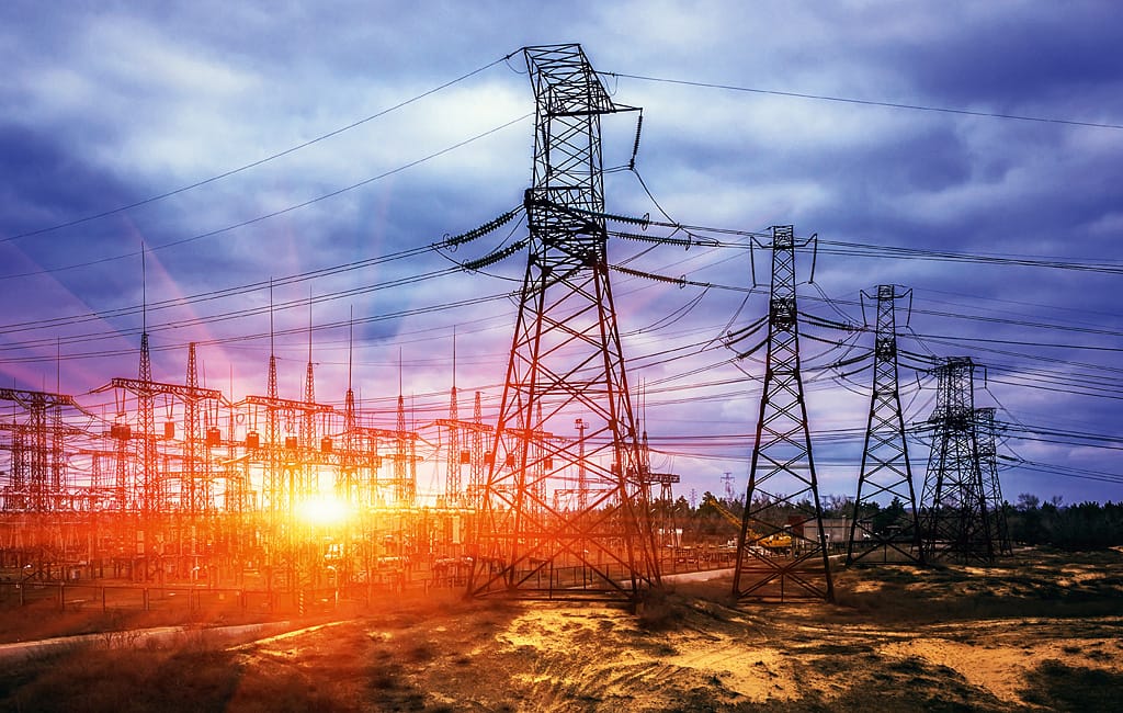 High-voltage substation and transmission towers at sunset